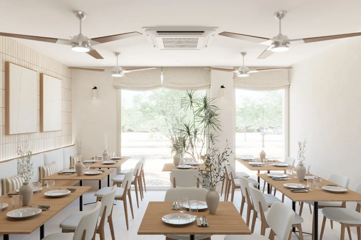 Comedor con mesas de madera preparadas, sillas claras y luz natural junto a los ventanales